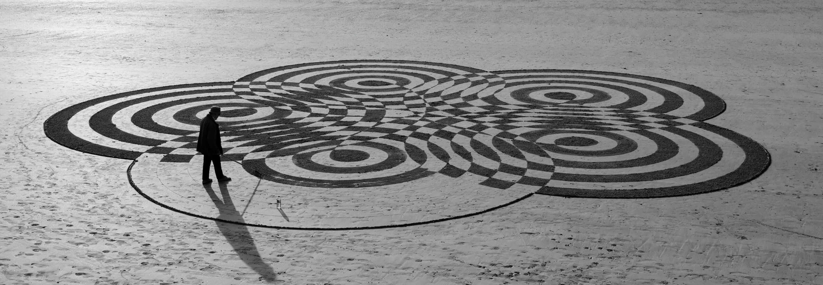 Image of a man creating art in the sand